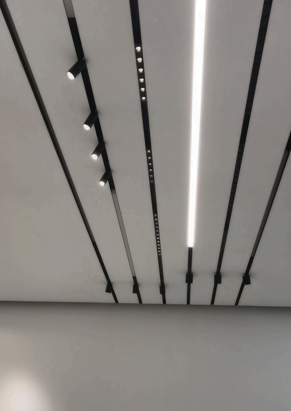 Magnetic tracks with spots and linear lights on a ceiling