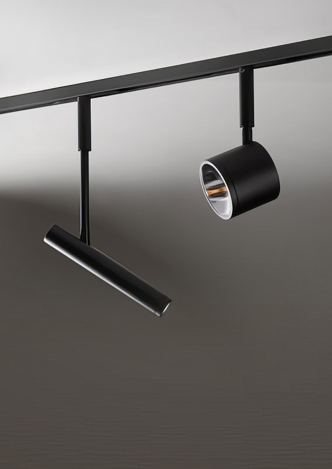 Two black magnetic spots on a track against a grey wall