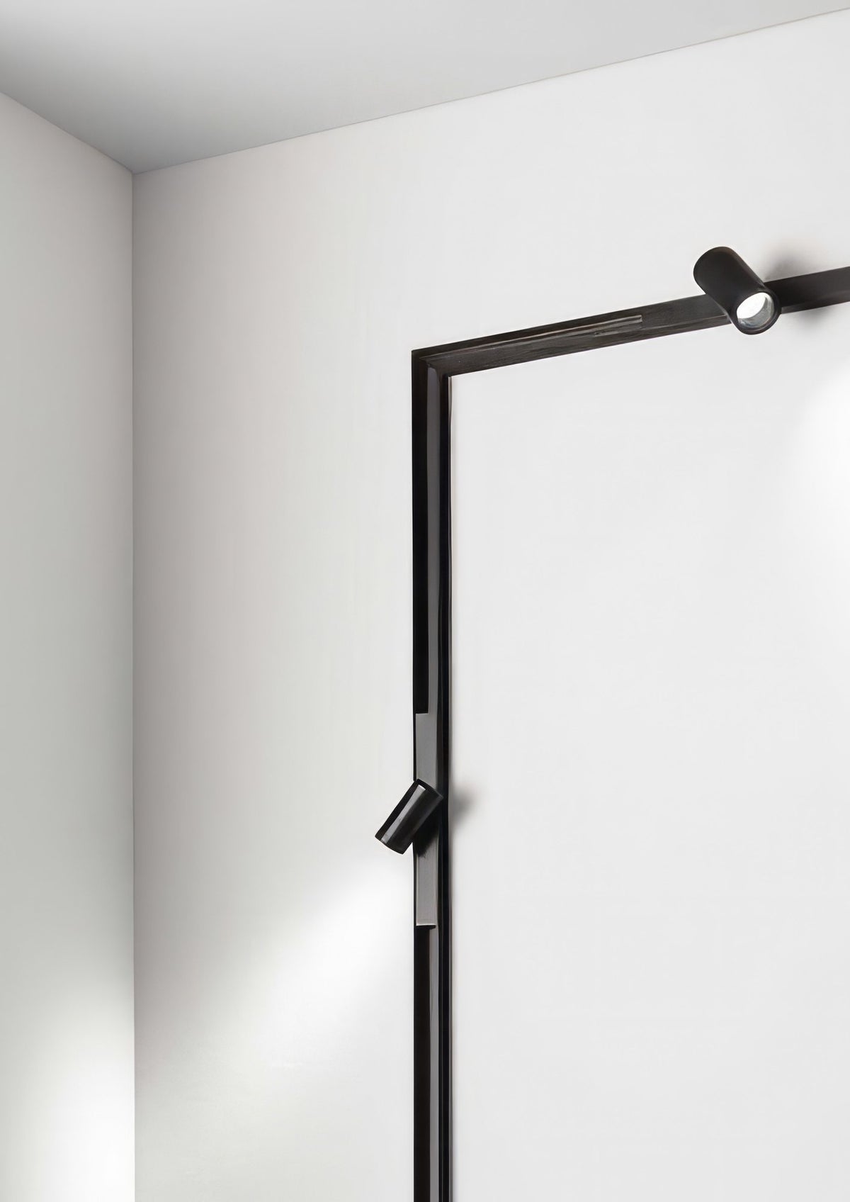 A magnetic track running from the ceiling down a white wall with two spots